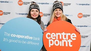 two women holding up centrepoint signs