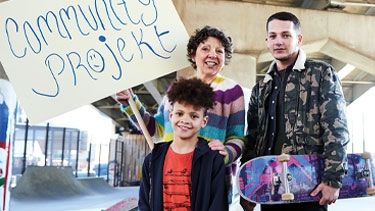 Photo of a woman with her two sons at a skatepark.