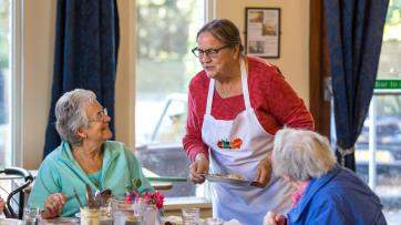 blank alt=“members of Café Abundance serving food